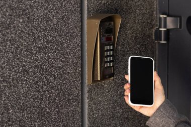 Kadın akıllı telefonla kapıyı açar. Yüksek kalite fotoğraf