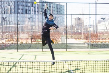 Genç Padel oyuncusu yüksek topları yakalayarak antrenman yapıyor. Yüksek kalite fotoğraf