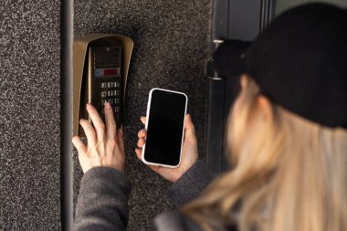 Kadın akıllı telefonla kapıyı açar. Yüksek kalite fotoğraf
