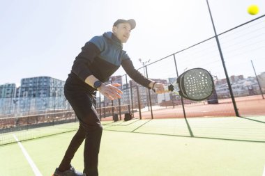 Genç Padel oyuncusu yüksek topları yakalayarak antrenman yapıyor. Yüksek kalite fotoğraf