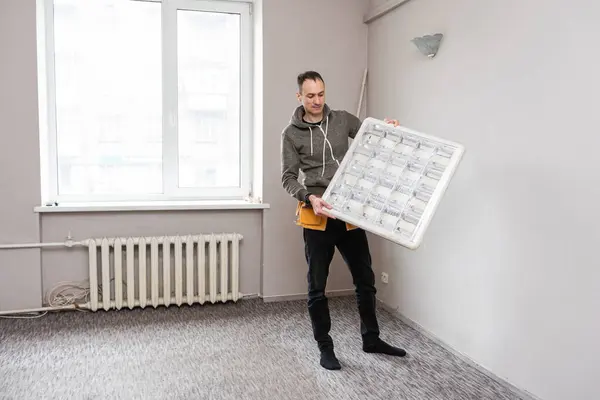 Maintenance man changing light bulbs in office. High quality photo