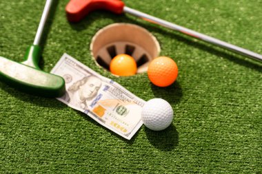 Para, çimlerin üzerinde mini golf topları. Spor bahsi kavramı.