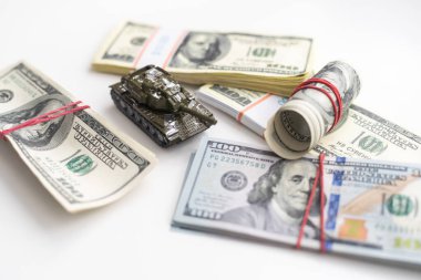 100 dolarlık banknotlardaki oyuncak tankları kapatın. Savaş maliyetleri, askeri harcamalar ve ekonomik kriz kavramı. Yüksek kalite fotoğraf