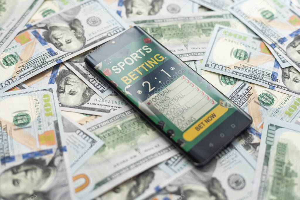 Sports betting website in a mobile phone screen, money. High quality photo