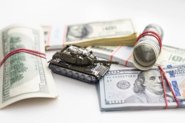 100 dolarlık banknotlardaki oyuncak tankları kapatın. Savaş maliyetleri, askeri harcamalar ve ekonomik kriz kavramı. Yüksek kalite fotoğraf