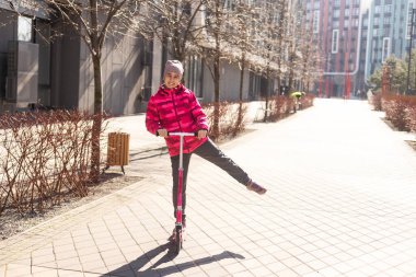 Parktaki bir yolda scooter süren küçük tatlı bir kız. Yüksek kalite fotoğraf