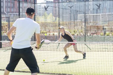 Padel kortunda raketlerle poz veren iki gülümseyen sporcunun portresi. Padel oyuncuları. Yüksek kalite fotoğraf