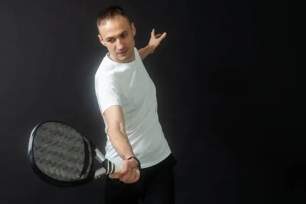 stock image Portrait of man playing paddle tennis in position to hit a backhand ball black isolated background. Front view. High quality photo