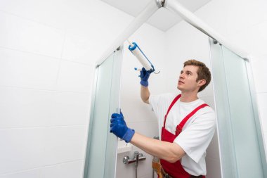 Tesisatçı silikon kartuş duş kabinin alüminyum çıta sabitleme kullanarak.