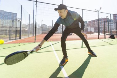 Raket tenis koçu, konutun ön tarafında bir raket kortunda öğretmenlik yapıyor. Yüksek kalite fotoğraf