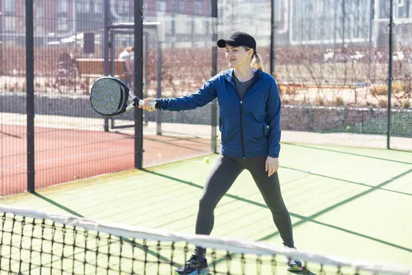 stock image Determined sporty young woman playing padel in court. High quality photo