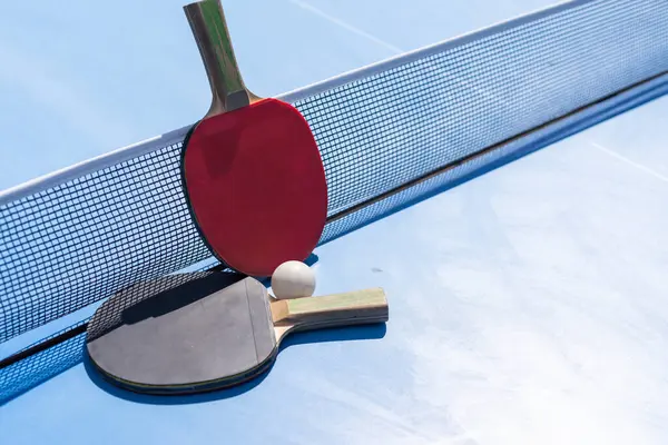 Zwei Tischtennis Oder Tischtennisschläger Und Ball Auf Blauem Tisch Mit Stockfoto