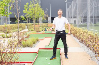 Oyuncu, mini golf sahasındaki vuruşuna bakıyor. Yüksek kalite fotoğraf