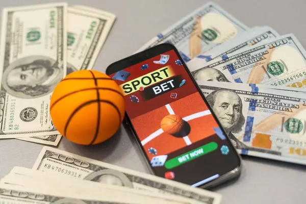 stock image Smartphone with gambling mobile application and basketball ball with money close-up. Sport and betting concept. High quality photo