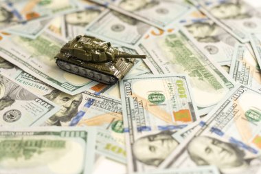 100 dolarlık banknotlardaki oyuncak tankları kapatın. Savaş maliyetleri, askeri harcamalar ve ekonomik kriz kavramı. Yüksek kalite fotoğraf