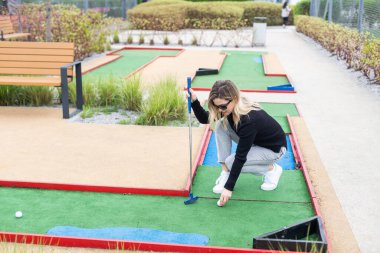 Mini golf oynayan bir kadın. Yaz sporu ve boş zaman aktivitesi. Yüksek kalite fotoğraf