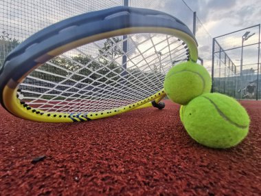  Sarı tenis topları ve tenis kortu yüzeyinde iki raket, üst manzara tenis sahnesi. Yüksek kalite fotoğraf