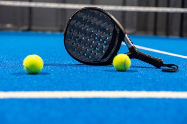 Siyah profesyonel raket tenis raketi ve mavi arka planda doğal ışıklandırmalı top. Yatay spor temalı poster, tebrik kartları, başlıklar, web sitesi ve uygulama. Yüksek kalite fotoğraf