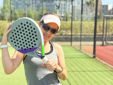 Açık sahada antrenman yaparken kürek çeken mutlu bayan tenisçi. Uzayı kopyala Yüksek kalite fotoğraf