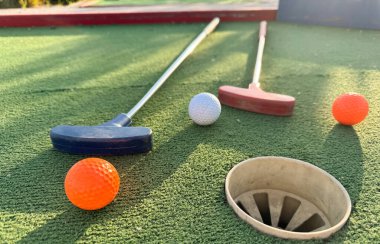 Mini golf sopaları ve farklı renkte toplar suni çimlerin üzerine konmuş. Yüksek kalite fotoğraf