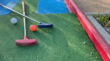 Sentetik çimlerin üzerinde golf topları olan renkli golf sopaları. Yüksek kalite fotoğraf