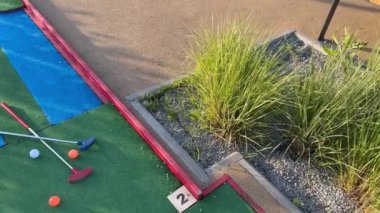 Mini golf sopaları ve farklı renkte toplar suni çimlerin üzerine konmuş. Yüksek kalite fotoğraf