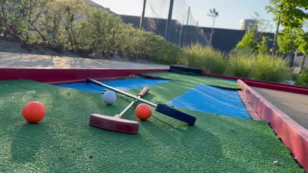合成草の上のゴルフ ボールが付いている多彩なゴルフ パター 高品質の写真 — ストック動画