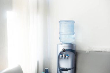 Blue water gallon on water cooler in office clipart