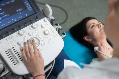 Kadın endokrinolog ultrason ofisinde kadın bir hastaya ultrasonografi yapıyor. Ultrason tanıları.