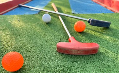 Sentetik çimlerin üzerinde golf topları olan renkli golf sopaları. Yüksek kalite fotoğraf
