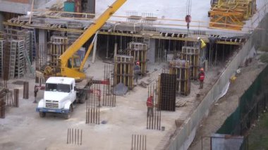 En tepede bir vinç bulunan yüksek katlı bir bina inşaatı. Yüksek kalite 4k görüntü