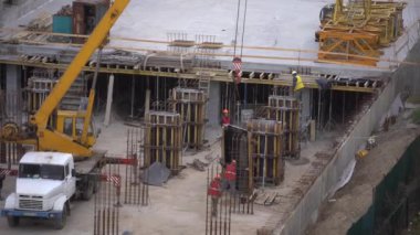 En tepede bir vinç bulunan yüksek katlı bir bina inşaatı. Yüksek kalite 4k görüntü