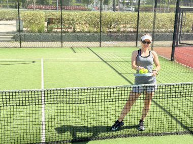 Kapalı alanda padel oynayan bir kadın genç sporcu Padel oyuncusu raketle topa vuruyor. Yüksek kalite fotoğraf