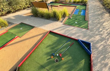 Mini golf sopaları ve farklı renkte toplar suni çimlerin üzerine konmuş. Yüksek kalite fotoğraf