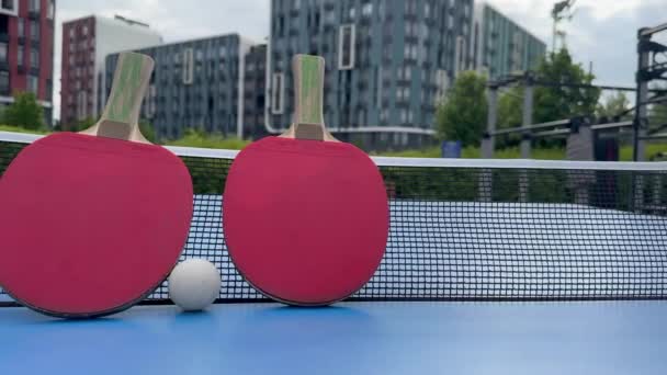 Two Table Tennis Rackets Lie Blue Tennis Table Covering White — Stockvideo