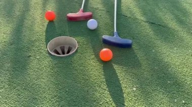 Sentetik çimlerin üzerinde golf topları olan renkli golf sopaları. Yüksek kalite fotoğraf