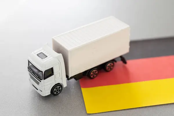 stock image Mini toy at table with blurred background. Industrial shipping concept. toy truck, germany flag. High quality photo