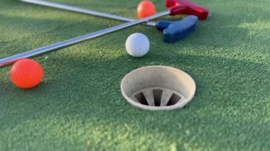 Sentetik çimlerin üzerinde golf topları olan renkli golf sopaları. Yüksek kalite fotoğraf