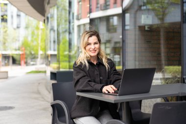 Bir kafede uzak bir işte çalışan genç bir kadın. Yüksek kalite fotoğraf