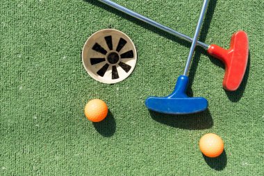 Mini golf sopaları ve farklı renkte toplar suni çimlerin üzerine konmuş. Yüksek kalite fotoğraf