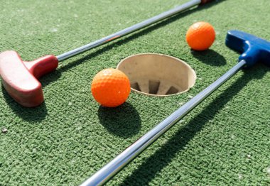 Sentetik çimlerin üzerinde golf topları olan renkli golf sopaları. Yüksek kalite fotoğraf