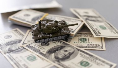 Dolar banknotlarının arka planında oyuncak tankı var. Yüksek kalite fotoğraf