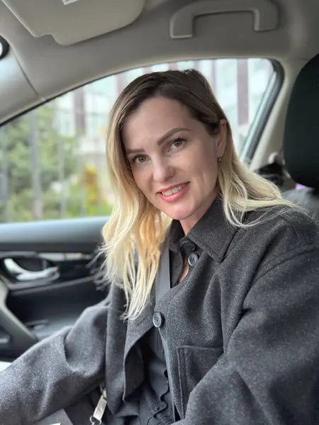 Stock image stylish and expressive blonde woman sitting in modern car and looking at camera, horizontal banner. High quality photo