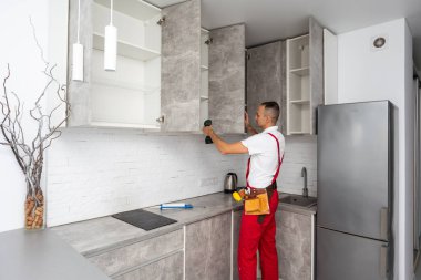 İşçi mutfağa dolap kapısı kuruyor. Yüksek kalite fotoğraf