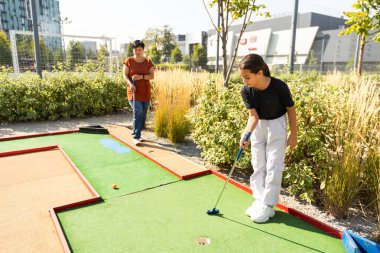 Anne ve küçük kızı sahada topa vurmak için alıştırma yapıyorlar. Yüksek kalite fotoğraf