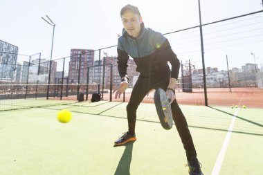 Ağ arkasında yeşil çim bir padel kortunda padel oynayan adam. Yüksek kalite fotoğraf