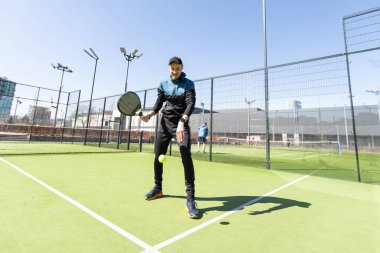 Genç Padel oyuncusu yüksek topları yakalayarak antrenman yapıyor. Yüksek kalite fotoğraf