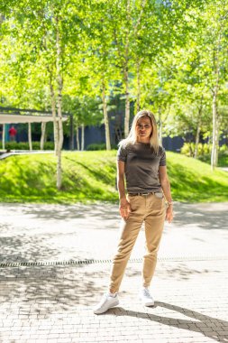 Ofis binasının parkında yürüyen güzel bir şehir kadını. Yüksek kalite fotoğraf. Yüksek kalite fotoğraf