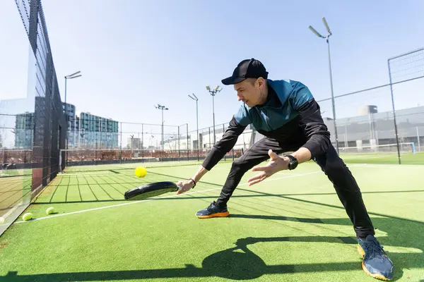 Ağ arkasında yeşil çim bir padel kortunda padel oynayan adam. Yüksek kalite fotoğraf