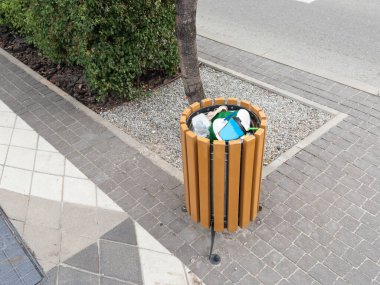 A ordinary trash can on the street. High quality photo clipart